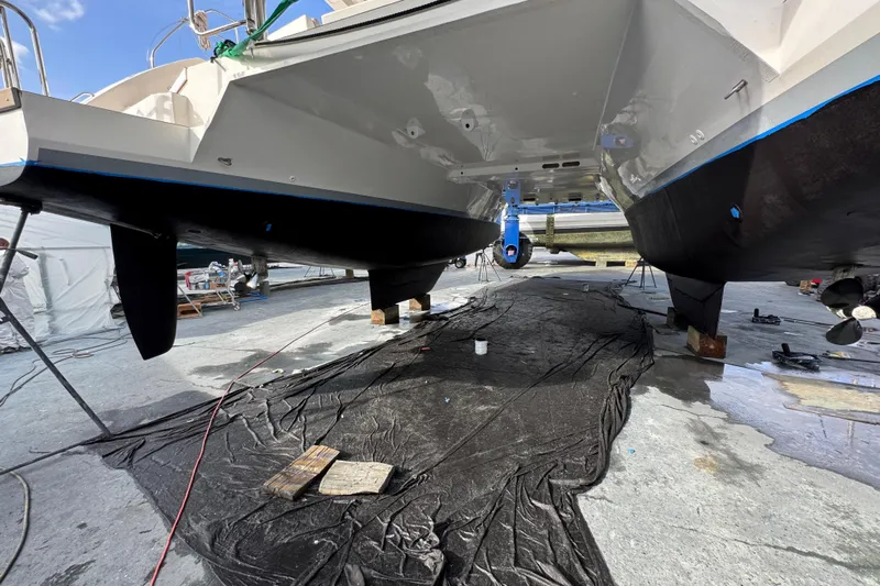Sundecker Yacht Photos Pics 2021 Leopard 45 catamaran in dry dock, showcasing hull and propellers.