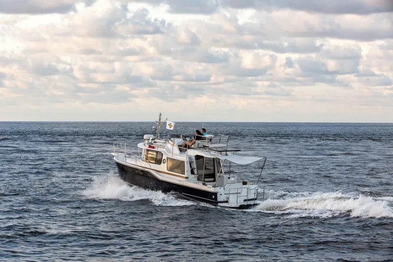  Yacht Photos Pics 2026 Ranger Tugs R-29 CB cruising on open water under cloudy skies.