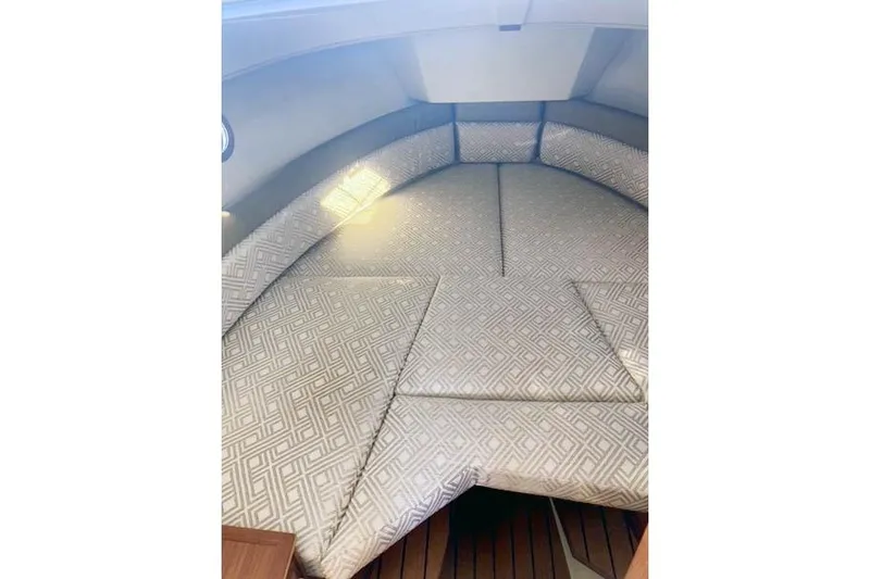  Yacht Photos Pics 2021 Ranger Tugs R-25 interior cabin with patterned cushions and wooden flooring.