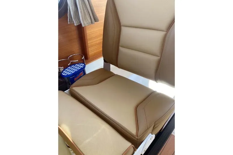  Yacht Photos Pics 2021 Ranger Tugs R-25 interior seat with tan upholstery and wooden accents.