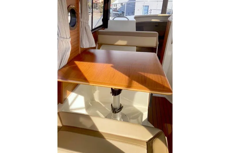  Yacht Photos Pics Interior of 2021 Ranger Tugs R-25 with wooden table and seating area.