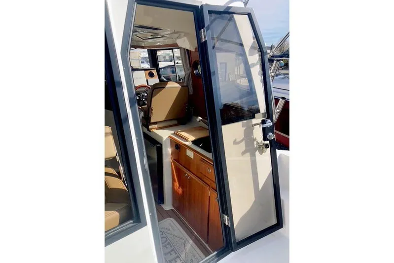  Yacht Photos Pics 2021 Ranger Tugs R-25 interior view with open door, showcasing cabin and helm.
