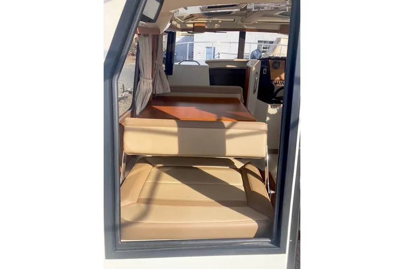  Yacht Photos Pics Interior view of 2021 Ranger Tugs R-25 boat with beige seating and wooden table.