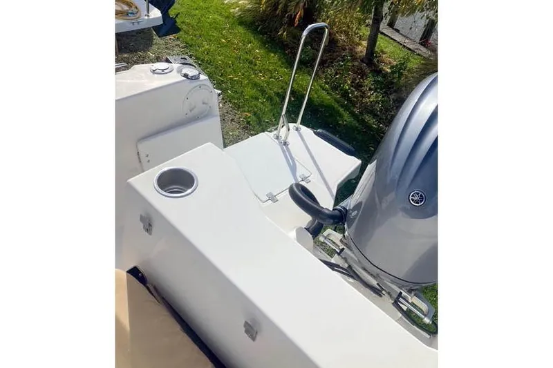  Yacht Photos Pics 2021 Ranger Tugs R-25 boat stern with motor and cup holder, outdoor setting.
