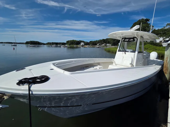 No Name Yacht Photos Pics 2021 Regulator 31 CC boat docked on a calm lake under a clear blue sky.