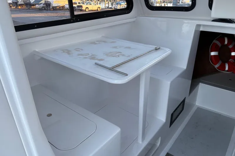  Yacht Photos Pics Interior of a 1994 Custom Workboat with seating, table, and life preserver.