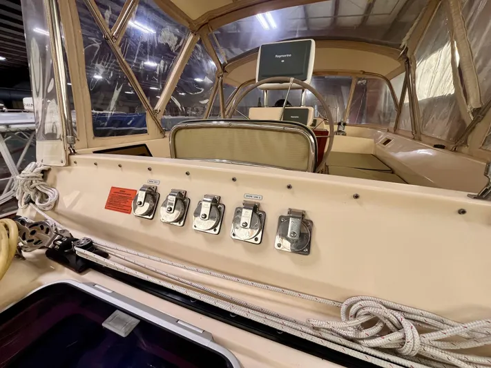 Intrepid II Yacht Photos Pics 2008 Island Packet 465 yacht cockpit with control panel and ropes in a covered marina.