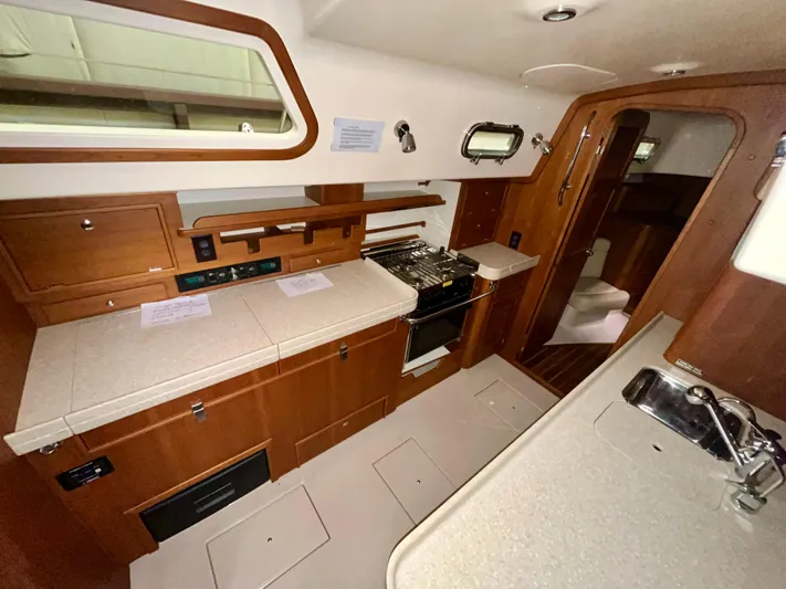 Intrepid II Yacht Photos Pics Interior of 2008 Island Packet 465 yacht, featuring a well-equipped kitchen with wooden cabinetry.
