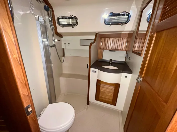 Intrepid II Yacht Photos Pics Luxurious bathroom in 2008 Island Packet 465 yacht with shower, sink, and wooden cabinetry.