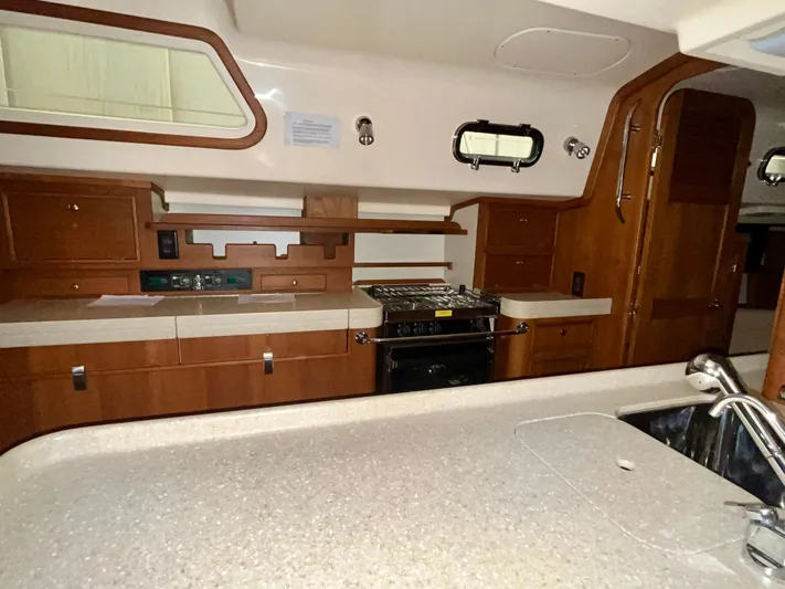 Intrepid II Yacht Photos Pics 2008 Island Packet 465 yacht interior kitchen with wooden cabinets and modern appliances.