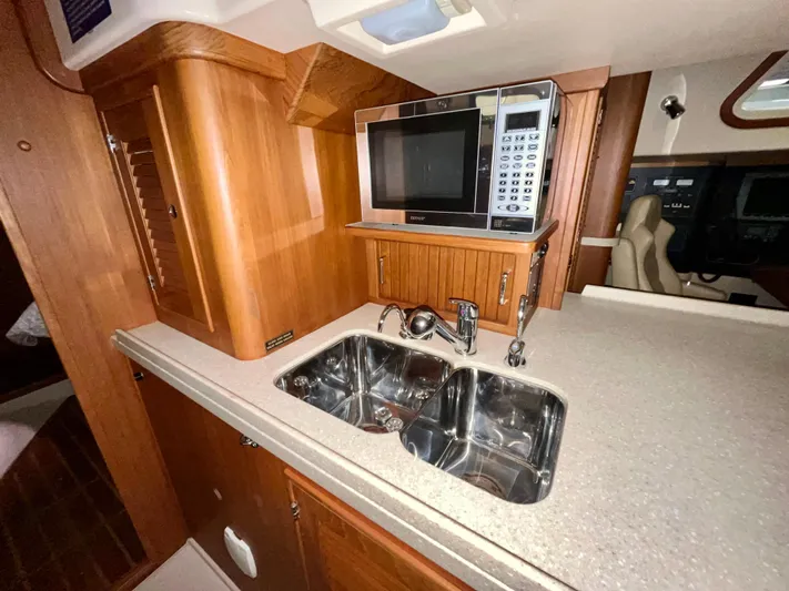 Intrepid II Yacht Photos Pics Island Packet 465 yacht kitchen with microwave, dual sink, and wooden cabinetry, 2008 model.