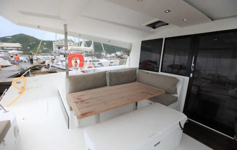 La Mer Kat Yacht Photos Pics Outdoor seating area on a 2016 Fountaine Pajot Lucia 40 catamaran, docked at a marina.