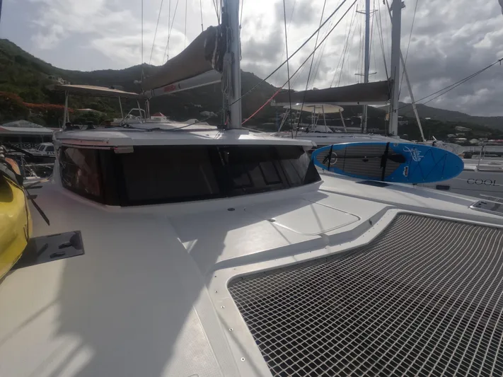 La Mer Kat Yacht Photos Pics 2016 Fountaine Pajot Lucia 40 catamaran with paddleboard, docked in a scenic marina.