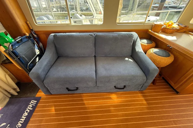  Yacht Photos Pics Interior of 2006 Mainship 34 Trawler with blue sofa and wooden flooring.