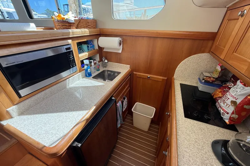  Yacht Photos Pics 2006 Mainship 34 Trawler kitchen with microwave, sink, and stove in compact layout.