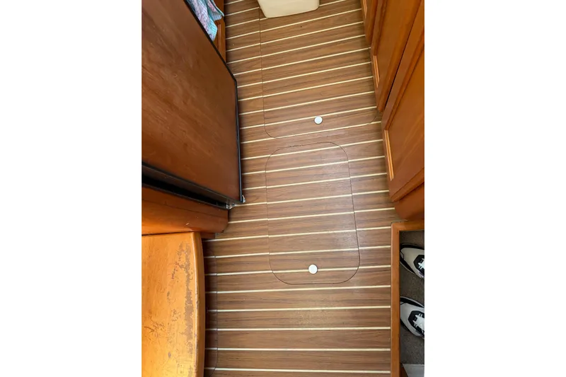  Yacht Photos Pics Wooden floor of 2006 Mainship 34 Trawler, featuring striped design and storage hatch.