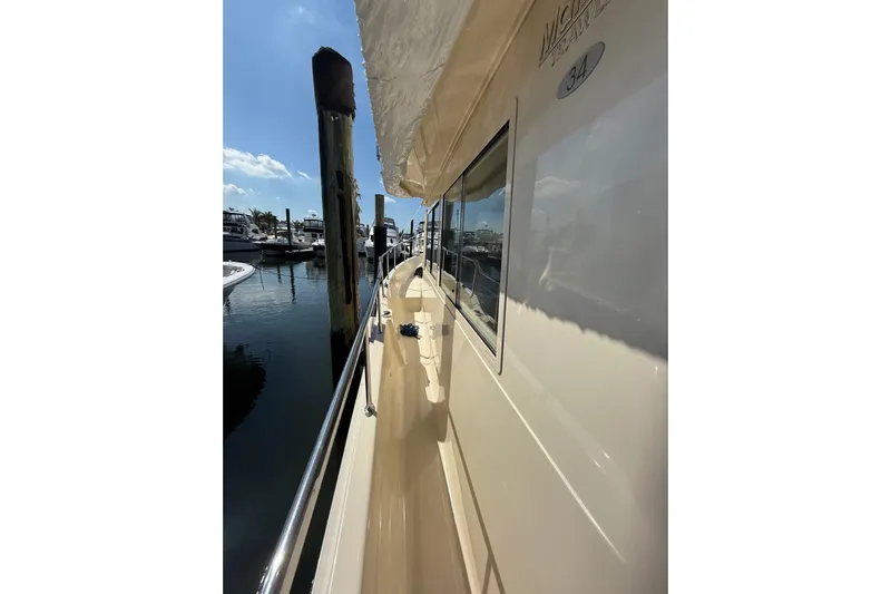  Yacht Photos Pics 2006 Mainship 34 Trawler side view at marina, showcasing sleek design and docked boats.