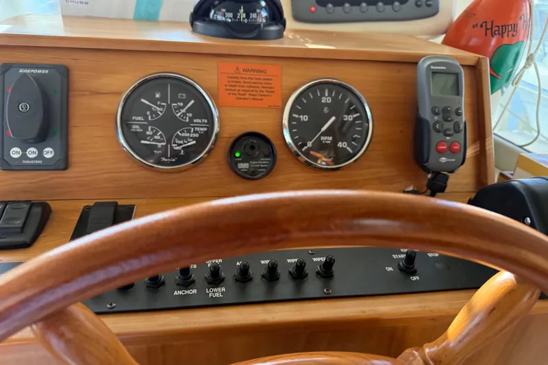  Yacht Photos Pics 2006 Mainship 34 Trawler dashboard with gauges, controls, and wooden steering wheel.