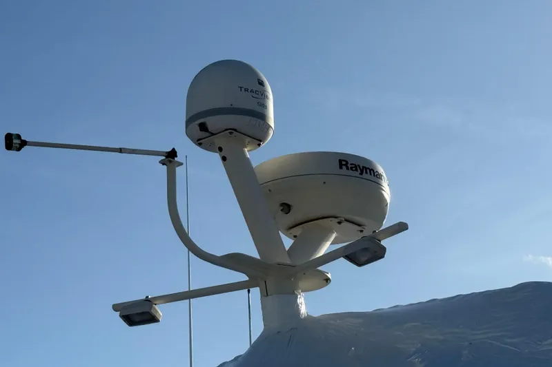  Yacht Photos Pics Radar and satellite equipment on 2006 Mainship 34 Trawler against clear blue sky.