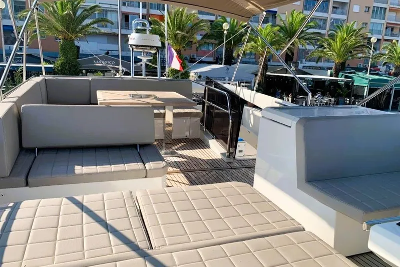 Fly Away Yacht Photos Pics Luxurious 2018 Prestige 520 yacht deck with seating and dining area, surrounded by palm trees.