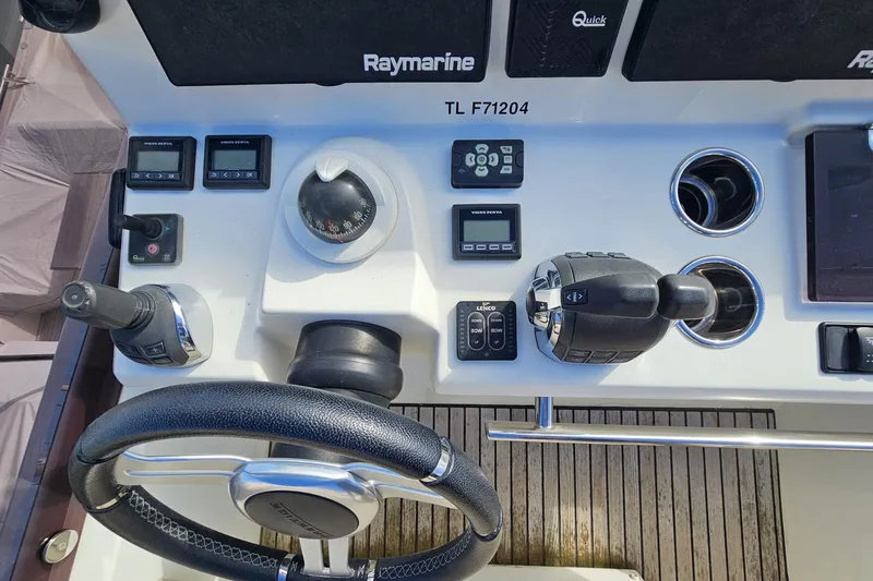 Fly Away Yacht Photos Pics Control panel of a 2018 Prestige 520 yacht with steering wheel and navigation instruments.