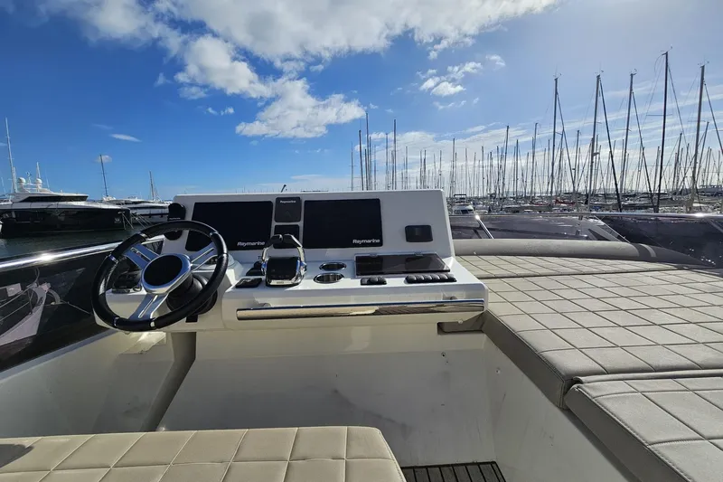 Fly Away Yacht Photos Pics 2018 Prestige 520 yacht helm with modern controls, docked in a marina under a blue sky.