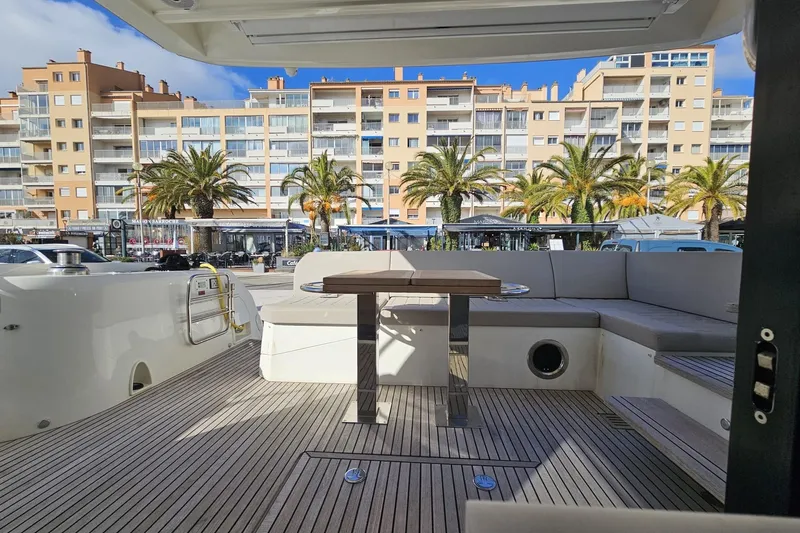 Fly Away Yacht Photos Pics Deck view of 2018 Prestige 520 yacht with cityscape and palm trees in background.