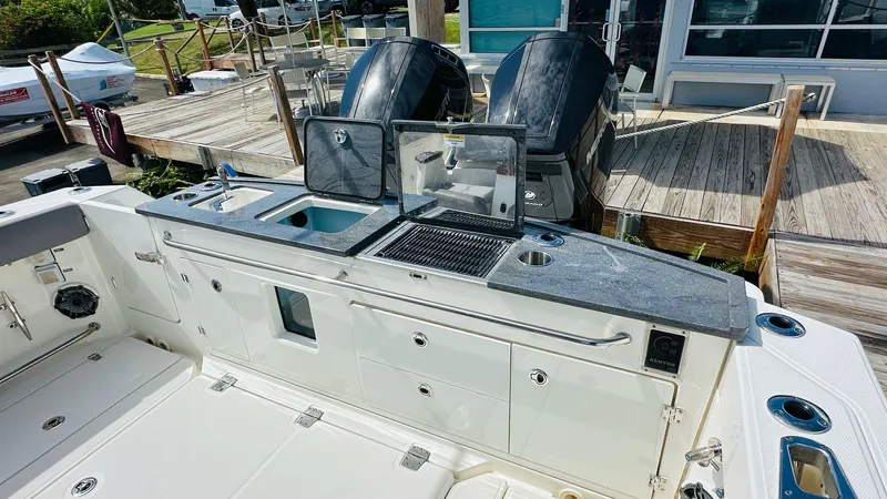  Yacht Photos Pics 2023 Boston Whaler 360 Outrage boat with outdoor kitchen and dual engines at dock.