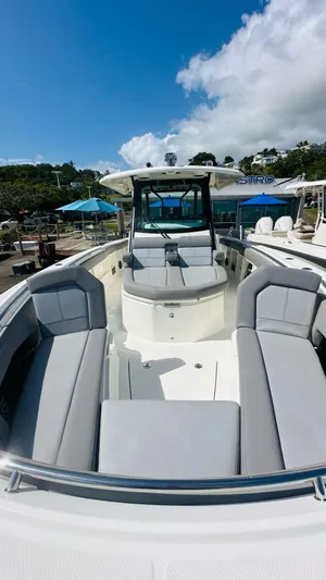  Yacht Photos Pics 2023 Boston Whaler 360 Outrage boat with spacious seating and sleek design under a clear blue sky.