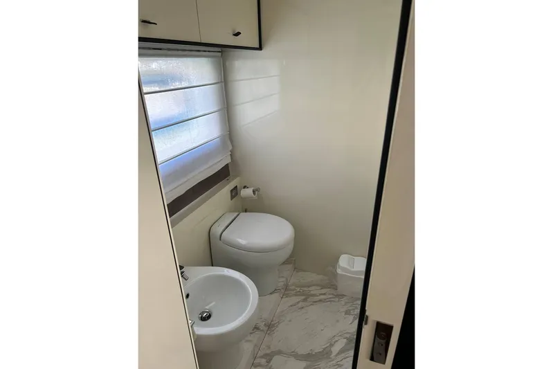  Yacht Photos Pics Bathroom interior of 2023 Cranchi Sessantasette 67 yacht, featuring modern fixtures and marble flooring.