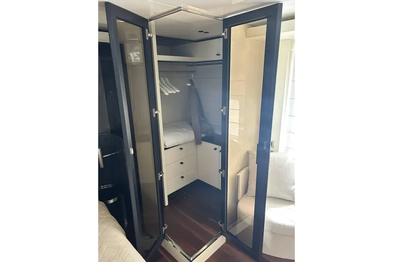  Yacht Photos Pics Luxurious closet interior on 2023 Cranchi Sessantasette 67 yacht, featuring glass doors and modern design.