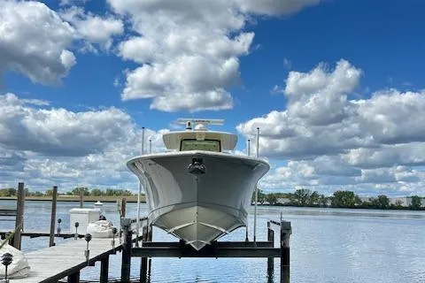 Seas Today Yacht Photos Pics 2019 Scout 355 LXF boat docked under a cloudy blue sky.