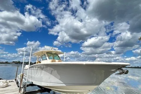 Seas Today Yacht Photos Pics 2019 Scout 355 LXF boat docked under a vibrant cloudy sky.