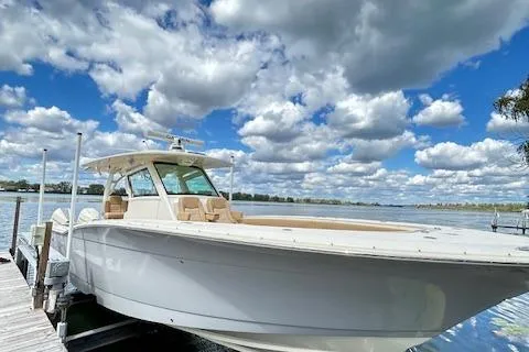 Seas Today Yacht Photos Pics 2019 Scout 355 LXF boat docked under a vibrant, cloudy sky.