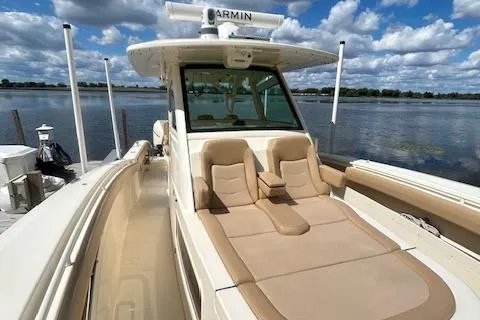 Seas Today Yacht Photos Pics 2019 Scout 355 LXF boat with tan seating, docked by a scenic lake.
