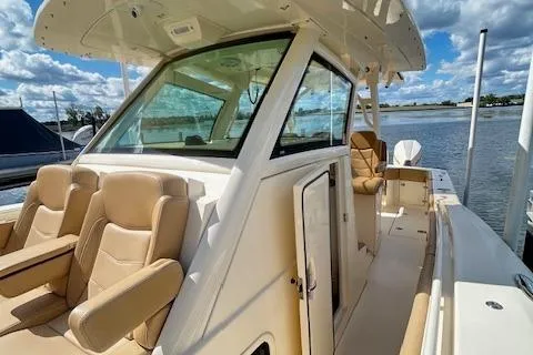 Seas Today Yacht Photos Pics 2019 Scout 355 LXF boat with tan seating, docked by a calm waterway.