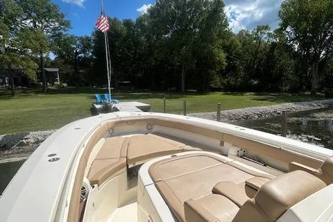 Seas Today Yacht Photos Pics 2019 Scout 355 LXF boat with tan seating, docked near a grassy shoreline.