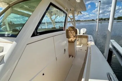 Seas Today Yacht Photos Pics 2019 Scout 355 LXF boat docked by the water under a blue sky.