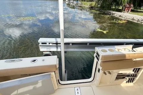 Seas Today Yacht Photos Pics 2019 Scout 355 LXF boat docked by a serene lake with clear water.