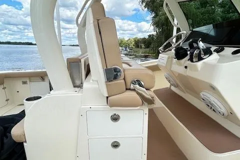 Seas Today Yacht Photos Pics 2019 Scout 355 LXF boat interior with beige seating and control panel by the water.