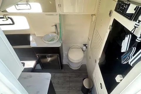 Seas Today Yacht Photos Pics 2019 Scout 355 LXF boat interior with compact bathroom, sink, and storage.