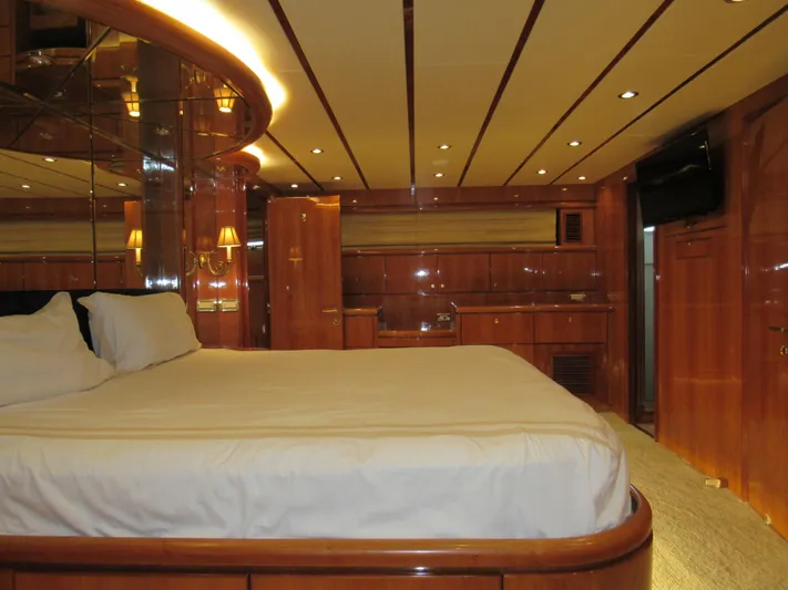Sanctuary Yacht Photos Pics Luxurious bedroom interior of 2002 Hargrave Raised Pilothouse yacht with wood paneling and ambient lighting.