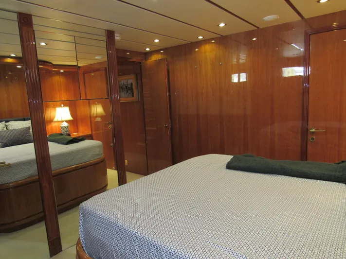 Sanctuary Yacht Photos Pics Luxurious bedroom interior of 2002 Hargrave Raised Pilothouse yacht with wood paneling and elegant bedding.