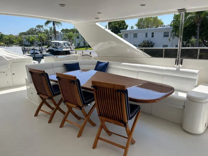 Sanctuary Yacht Photos Pics Outdoor dining area on 2002 Hargrave Raised Pilothouse yacht with wooden chairs and table.