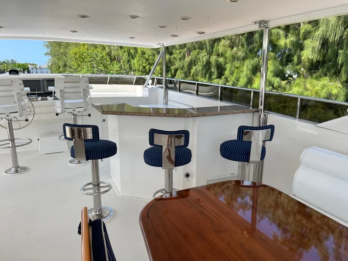 Sanctuary Yacht Photos Pics Luxurious 2002 Hargrave Raised Pilothouse yacht deck with bar stools and seating area.