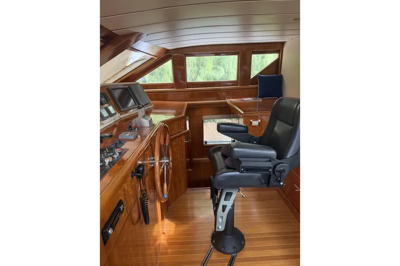 Sanctuary Yacht Photos Pics Luxurious 2002 Hargrave Raised Pilothouse interior with wooden helm and captain's chair.