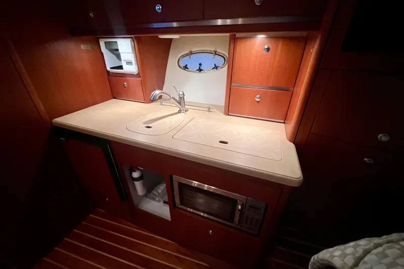 Blue Pearl Yacht Photos Pics 2005 Tiara Yachts 3200 Open galley with sink, microwave, and wooden cabinetry.