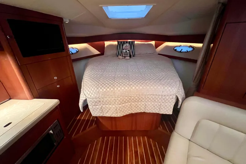 Blue Pearl Yacht Photos Pics Luxurious cabin interior of 2005 Tiara Yachts 3200 Open with cozy bed and wooden finish.