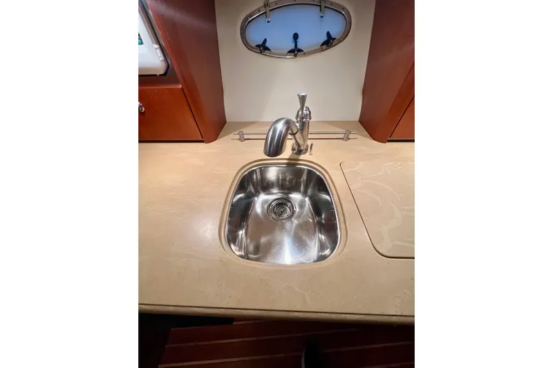 Blue Pearl Yacht Photos Pics 2005 Tiara Yachts 3200 Open kitchen sink with stainless steel faucet and porthole window.