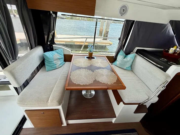 Remotely Workin' Yacht Photos Pics Interior of 2022 Jeanneau NC 1095 Coupe with cozy seating and table.